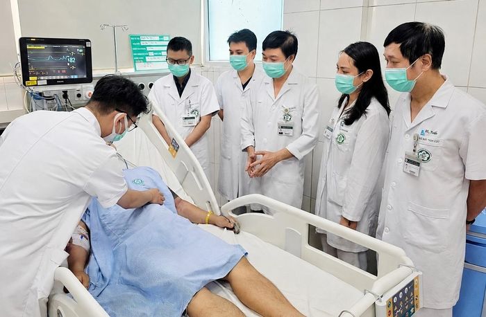 TS.BS Đỗ Văn Thành, Phó Viện trưởng và các bác sĩ Viện Y học nhiệt đới Bạch Mai, Bệnh viện Bạch Mai thăm khám cho nam người bệnh. (Ảnh: Nguyên Hà)