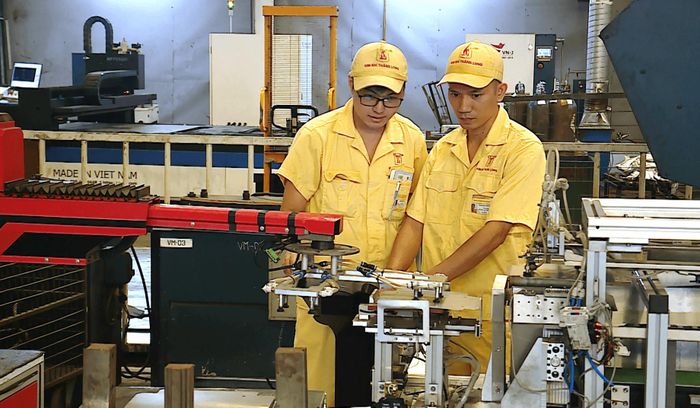 Anh Nguyễn Văn Thịnh (phải) cùng đồng nghiệp nghiên cứu thiết bị tự động hóa. Ảnh: Nguyễn Công