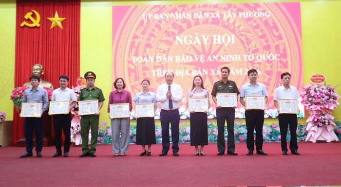 Ban tổ chức tặng giấy khen cho các tập thể có thành tính xuất sắc trong phong trào bảo vệ an ninh Tổ quốc trên địa bàn xã Tây Phương. Ảnh: Công Phương