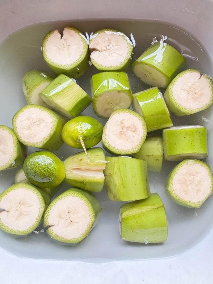 Chuối được rửa sạch vỏ và tước bớt phần vỏ bị đen, cắt khúc vừa ăn, thả ngay vào chậu nước pha chút chanh + muối, ngâm 15 phút cho ra bớt nhựa.