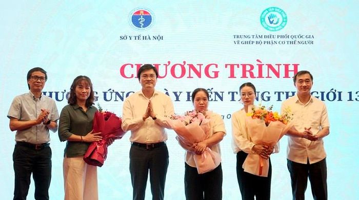 Thứ trưởng Trần Văn Thuấn và các đại biểu tặng hoa tri ân thân nhân người hiến tạng. Ảnh: Lê Bảo