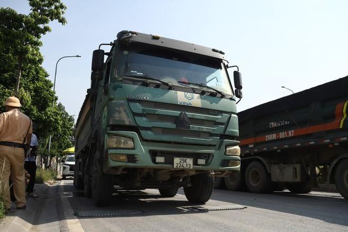 Tình trạng đất, cát,... rơi vãi từ xe tải xuống đường tiềm ẩn nguy cơ mất an toàn giao thông, đặc biệt với người đi xe máy khi phải tránh hoặc đi qua khu vực có vật liệu rơi vãi. (Ảnh Thành Long)