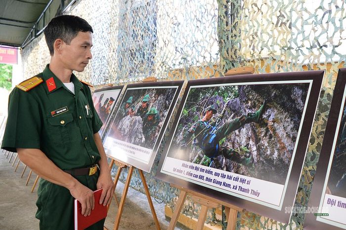 Một chiến sĩ xem lại bức ảnh ghi lại chính mình trong quá trình tìm kiếm, quy tập hài cốt liệt sĩ tại điểm cao 685, xã Thanh Thủy. Ảnh: T.Anh