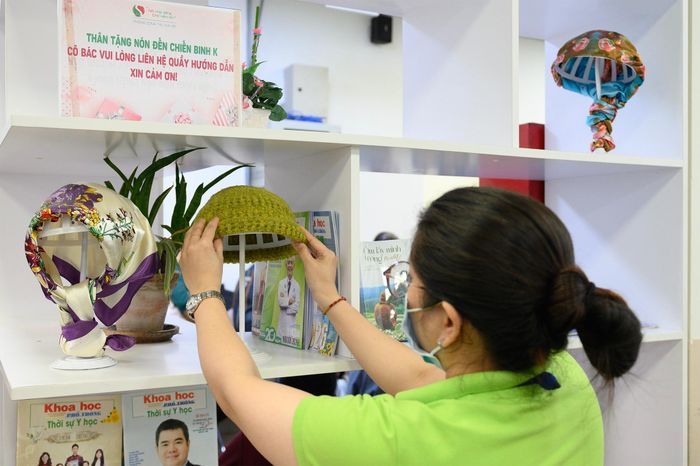  Không chỉ có sách, trên một số tủ còn trưng bày những chiếc mũ được chuẩn bị để gửi tặng bệnh nhân ung thư có nhu cầu. Những món quà nhỏ góp phần mang đến sự sẻ chia và động viên người bệnh trong quá trình điều trị. 