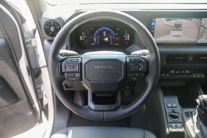 Vô lăng tròn 3 chấu bọc da của Land Cruiser FJ khá tương đồng trang bị có mặt trên Toyota Land Cruiser Prado hay Toyota Hilux. Trung tâm vô lăng là logo thương hiệu dạng chữ, xung quanh bố trí nhiều phím vật lý để điều khiển chức năng xe.