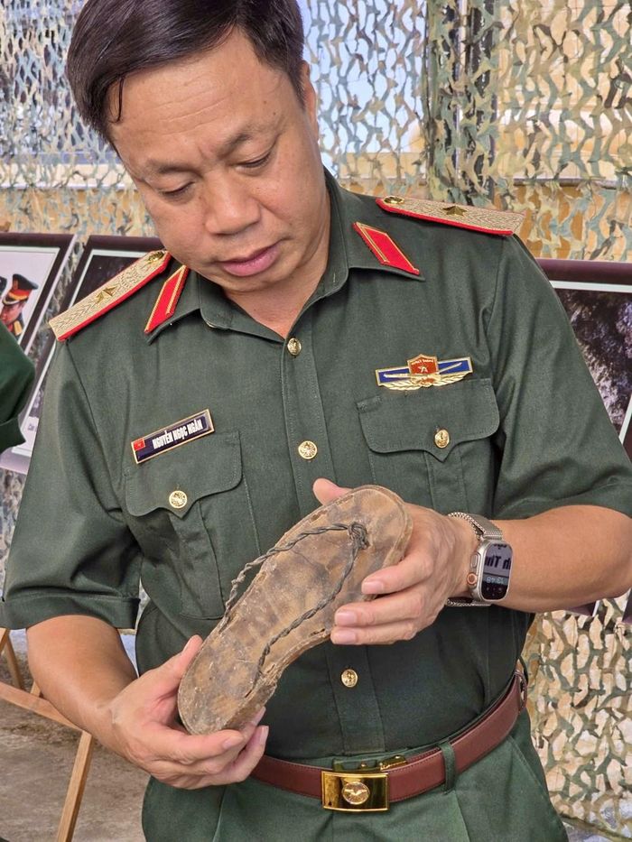 Trên tay Thiếu tướng Nguyễn Ngọc Ngân là di vật đôi dép nhựa đứt quai, quai dép được thay bằng sợi dây thông tin