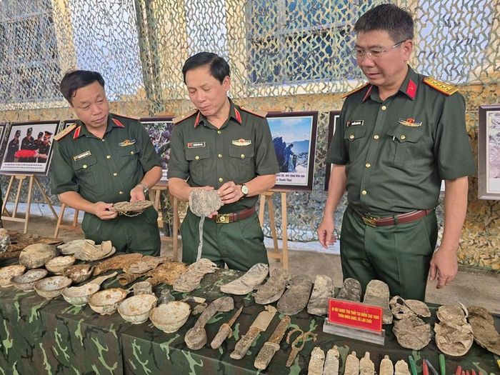 Thiếu tướng Nguyễn Hồng Thái (giữa), Phó Chính ủy Quân khu 2, Trưởng Ban Chỉ đạo về tìm kiếm, quy tập và xác định danh tính hài cốt liệt sĩ Quân khu 2;Thiếu tướng Nguyễn Ngọc Ngân (trái), Phó Chủ nhiệm Chính trị, Phó Trưởng ban Thường trực Ban Chỉ đạo về tìm kiếm, quy tập và xác định danh tính hài cốt liệt sĩ Quân khu 2 nhìn những di vật được tìm thấy tại điểm cao 1688
