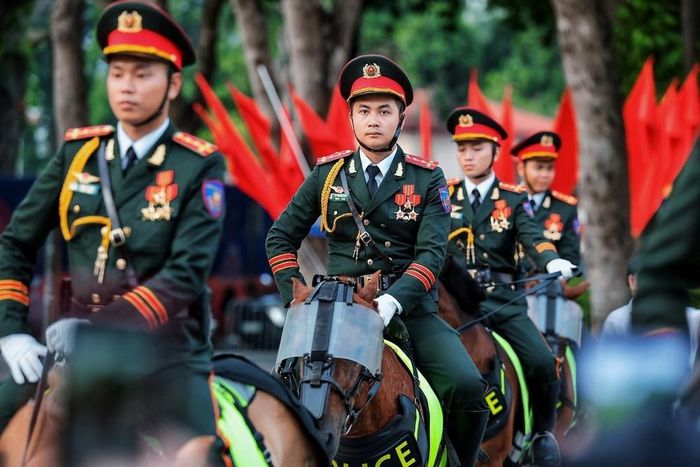 Hình ảnh cán bộ, chiến sĩ Cảnh sát cơ động Kỵ binh trong đội hình tổng duyệt nổi bật giữa không gian rợp cờ Tổ quốc tại khu vực trung tâm Hà Nội