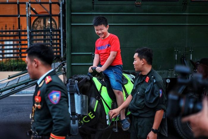 Niềm vui của một em nhỏ khi được trải nghiệm cưỡi ngựa dưới sự hướng dẫn, hỗ trợ của cán bộ, chiến sĩ Cảnh sát cơ động kỵ binh