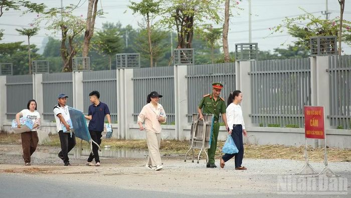 Lực lượng tình nguyện viên hỗ trợ nước cho thí sinh và phụ huynh tại điểm thi.