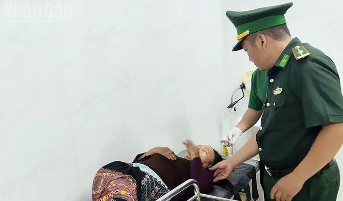 Cán bộ Đồn Biên phòng Chiềng On, Ban Chỉ huy Bộ đội Biên phòng tỉnh Sơn La thăm hỏi, động viên công dân Lào điều trị tại Trạm Kiểm soát Biên phòng Keo Muông. (Ảnh: QUÀNG HÙNG)