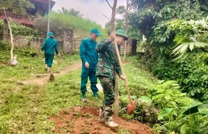 Cán bộ, chiến sĩ Ban Chỉ huy quân sự xã Chiềng Sinh và dân quân tự vệ xã cùng nhân dân trong xã trồng cây phân tán. Ảnh: Lê Lan