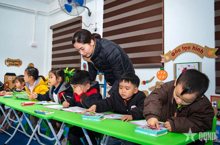 Học sinh lớp 4-5 tuổi của điểm trường liên cấp mới ở thôn Làng Nủ tô màu theo hướng dẫn của cô giáo, tháng 1-2025. Ảnh: TRUNG THÀNH