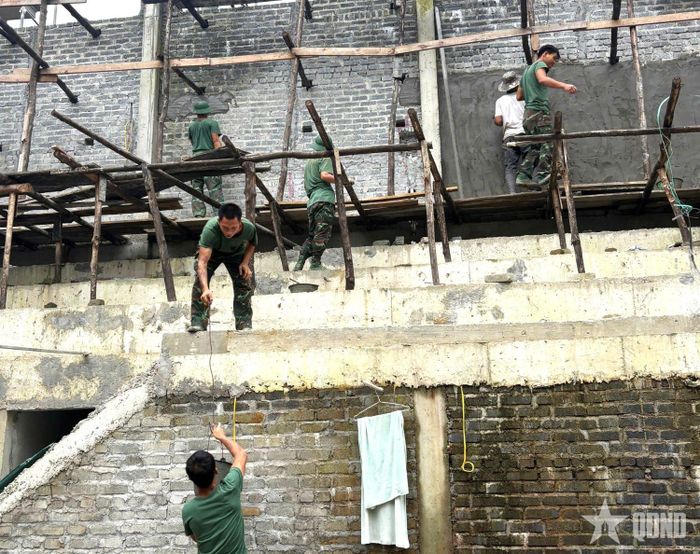 Cán bộ, chiến sĩ Trung đoàn 877, Bộ CHQS tỉnh Tuyên Quang, phối hợp với công nhân thi công các hạng mục của Trường Phổ thông nội trú liên cấp Tiểu học và THCS Pà Vầy Sủ.