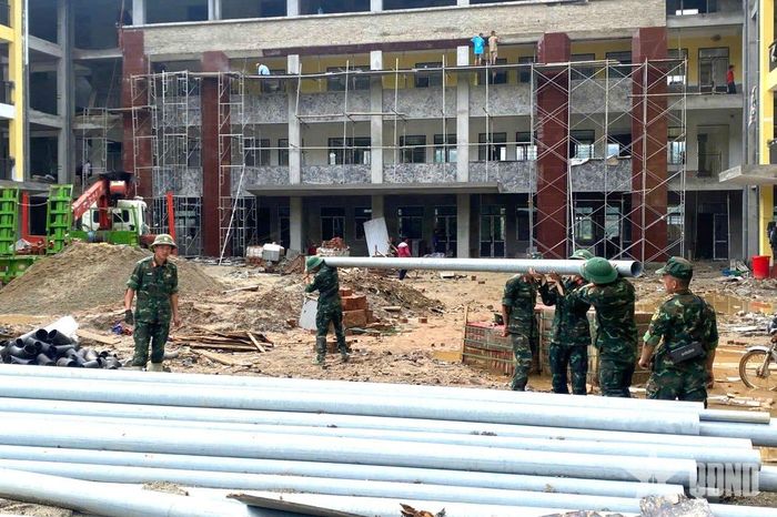 Cán bộ, chiến sĩ Trung đoàn 877 vận chuyển vật liệu, góp thêm nhân lực đẩy nhanh tiến độ hoàn thiện công trình.