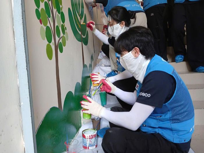 Các tình nguyện viên vẽ tranh tường tại Tiểu học Quang Trung.