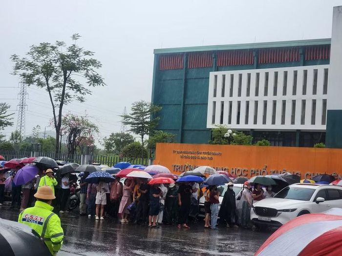 Phụ huynh đội mưa chờ đón các thí sinh.