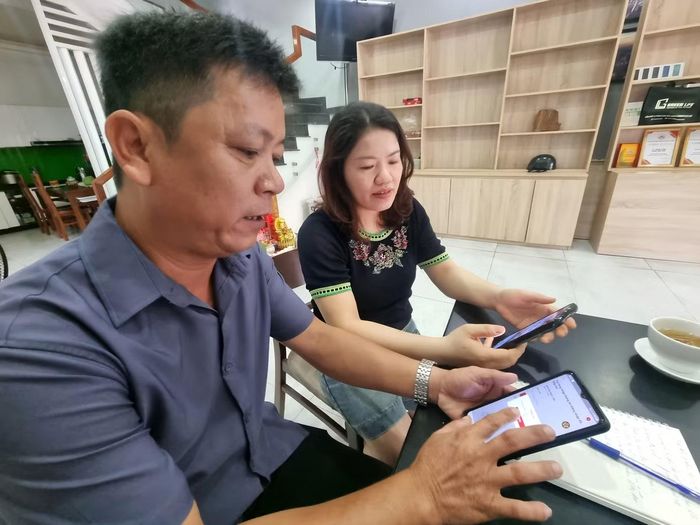Tổ trưởng Nguyễn Ngọc Lân hướng dẫn người dân sử dụng VNeID. Ảnh: Thanh Hiền