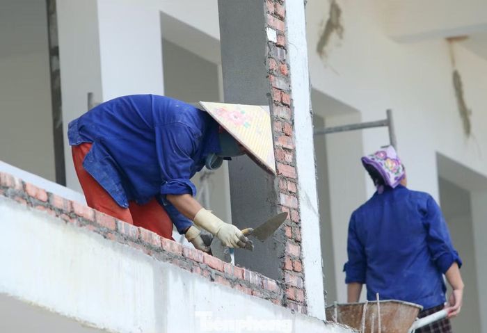 Trên công trường không chỉ có đàn ông, nhiều người phụ nữ cũng đảm nhận công việc từ phụ hồ, vận chuyển vật liệu đến xây tường.