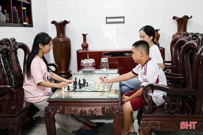 Em Trần Nữ Thiện Nhân luyện cờ trên máy tính và chơi cờ cùng em trai tại nhà