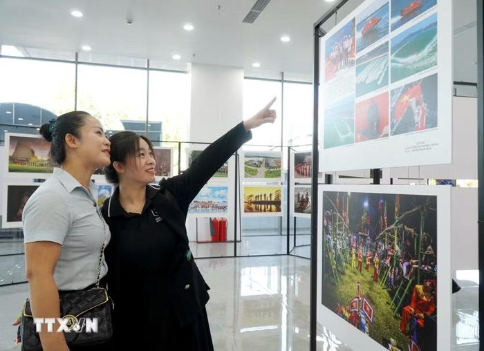 Đại biểu tham quan khu vực triển lãm ảnh. (Ảnh: Lê Phước Ngọc/TTXVN)