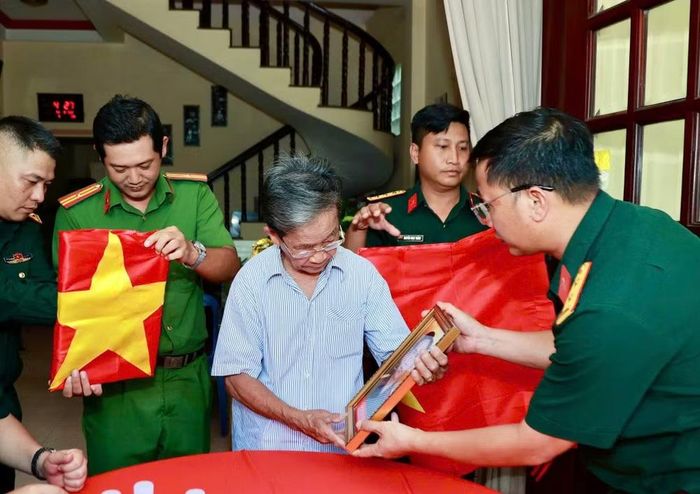 Ông Phan Văn Tư xúc động bên di ảnh hai người anh trai đã hy sinh. (Ảnh: Bộ Tư lệnh Thành phố Hồ Chí Minh cung cấp)