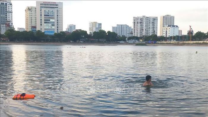 Người dân vô tư tắm ở Hồ Linh Đàm mặc dù đã có biển báo cấm tắm. Ảnh: Nguyễn Thắng/TTXVN