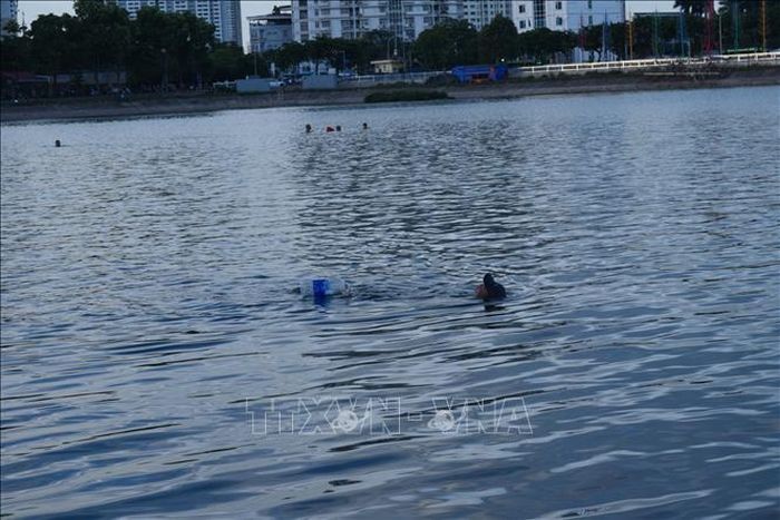 Mặc dù đã xảy ra một số vụ đuối nước trên hồ Linh Đàm nhưng người dân vẫn xuống tắm, bất chấp cảnh báo về an toàn. Ảnh: Nguyễn Thắng/TTXVN