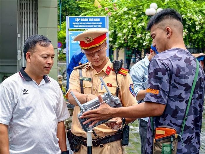Cán bộ đội Cảnh sát giao thông số 7, Phòng Cảnh sát giao thông Hà Nội, mời người vi phạm xem lại hình ảnh từ thiết bị điều khiển UAV, đảm bảo tính chính xác, khách quan, minh bạch.