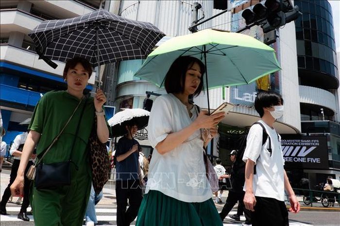 Người dân che ô tránh nắng nóng tại Tokyo, Nhật Bản. Ảnh: THX/TTXVN phát