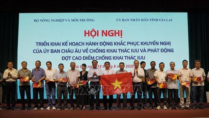 Thứ trưởng Bộ Nông nghiệp và Môi trường Võ Văn Hưng trao quà và cờ tổ quốc cho ngư dân. Ảnh: Đình Quân/TTXVN