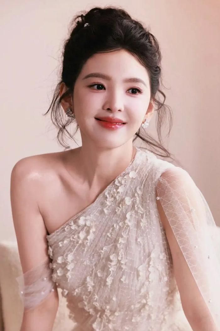 Chương Nhược Nam xuất hiện trong chiếc đầm voan trắng lệch vai, kết hợp kiểu tóc búi.