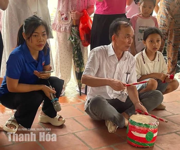 Nghệ nhân Lê Bá Tuất đánh trống cho các em thiếu nhi múa đèn.