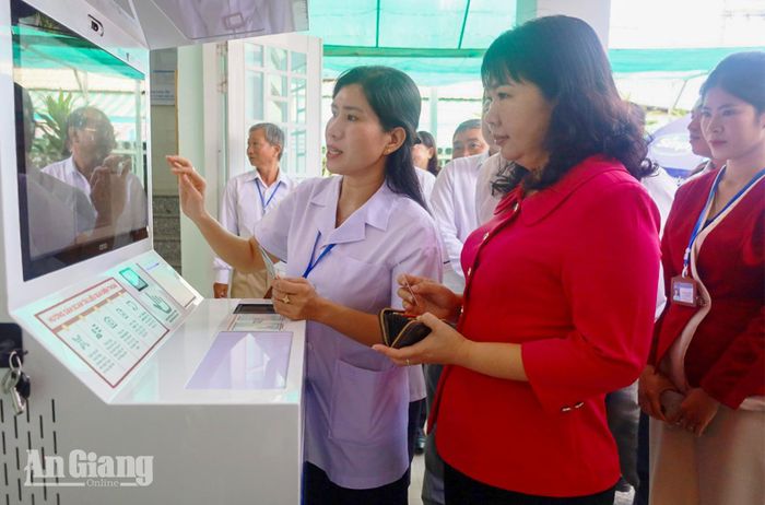 Các đại biểu tham quan việc triển khai bệnh án điện tử tại Trạm Y tế xã Châu Phú.