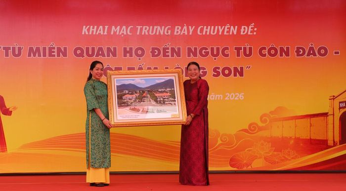  Bà Phạm Thị Tám (bên phải), Phó Giám đốc Bảo tàng - Thư viện tỉnh Bà Rịa - Vũng Tàu (cơ sở Côn Đảo) trao tặng bức ảnh Trung tâm Đặc khu Côn Đảo, Thành phố Hồ Chí Minh cho Bảo tàng Bắc Ninh số 1. 