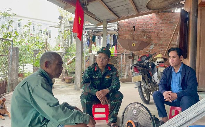 Thiếu tá Bùi Xuân Hùng, Chính trị viên phó Ban Chỉ huy Quân sự xã Quế Phước (giữa) gặp gỡ người dân để thu thập nguồn tin về liệt sĩ, mộ liệt sĩ. Ảnh: ĐVCC