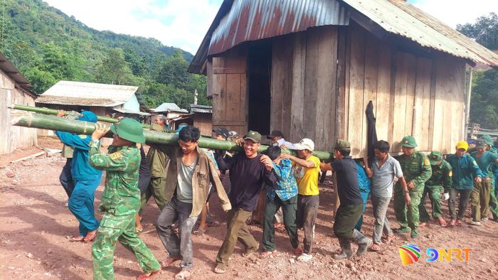 Cán bộ, chiến sĩ Đồn Biên phòng A Nông cùng các lực lượng di dời căn nhà khỏi khu vực nguy hiểm. Ảnh: HUỲNH CHÍN
