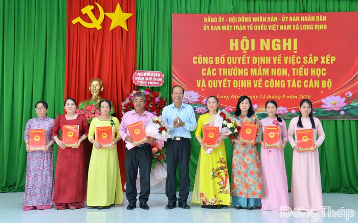 Đồng chí Nguyễn Ngọc Sơn, Phó Bí thư Đảng ủy, Chủ tịch UBND xã Long Định, trao các Quyết định sáp nhập trường và Quyết định về công tác cán bộ.