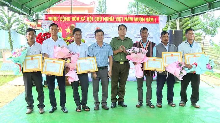 Đai diện Công an tỉnh và lãnh đạo xã Kon Chiêng trao giấy khen cho các cá nhân tại ngày hội. Ảnh: Minh Hoàng