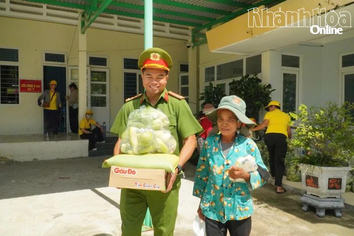 Cán bộ Công an xã Công Hải giúp người dân đưa những phần hàng nặng ra xe sau khi lựa chọn tại “Cửa hàng 0 đồng”.