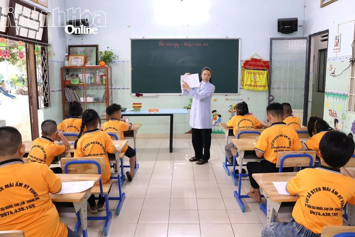 Nữ tu Mái ấm Hy Vọng hướng dẫn các em nhỏ tô màu tranh.