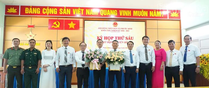 Lãnh đạo xã Phước Dinh tặng hoa chúc mừng ông Nguyễn Minh Tuấn và ông Võ Văn Ngân.