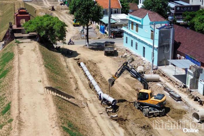 Công nhân, máy móc hạ đặt ống cống của hệ thống thoát nước phía trong tường thành.