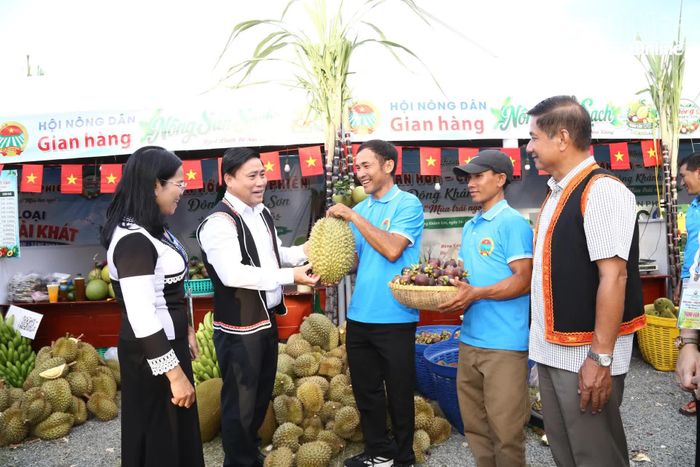 Đồng chí Lâm Đông và lãnh đạo xã Đông Khánh Sơn tham quan gian hàng trưng bày nông sản đặc trưng của xã. 