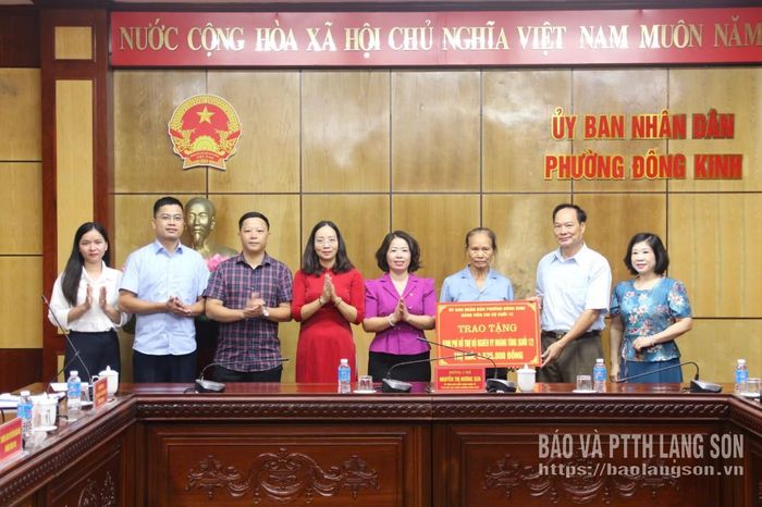 Lãnh đạo UBND phường Đông Kinh và đảng viên chi bộ khối 12trao biểu trưng kinh phí hỗ trợ cho người giám hộ cháu Vy Hoàng Tùng