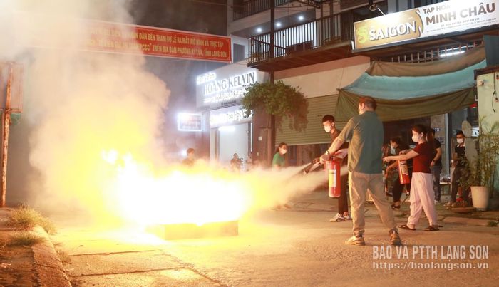 Người dân dùng bình chữa cháy xách tay dập lửa trong thực tập phương án