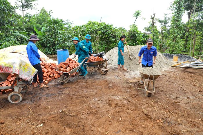 Đoàn viên, thanh niên cùng cán bộ, chiến sĩ vận chuyển gạch, cát phục vụ xây dựng ngôi nhà mới