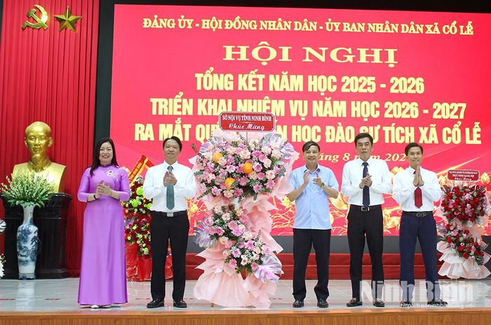 Lãnh đạo Sở Nội vụ tặng hoa chúc mừng thành tích xã Cổ Lễ đạt được trong năm học 2025-2026. Ảnh: Thành Trung