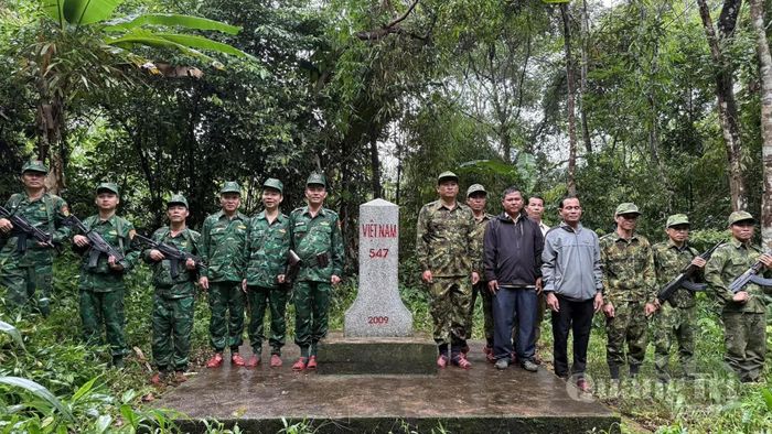 Lực lượng biên phòng và đại diện cấp ủy, chính quyền hai bên chụp ảnh lưu niệm tại mốc quốc giới 547 - Ảnh: N.M