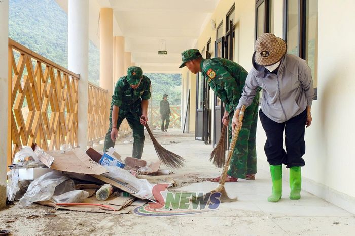 Cán bộ, chiến sĩ Đồn Biên phòng Mường Lạn hỗ trợ nhà trường thu gom, xử lý phế liệu xây dựng.